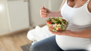 Acompanhamento nutricional na gestação: mulher grávida comendo salada.